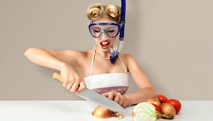 A girl cuts an onion in a mask to protect herself from tears