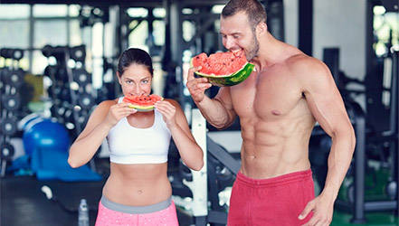 Sportovci jedí meloun v tělocvičně.